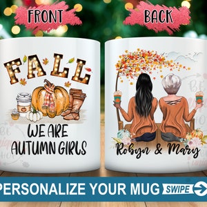 May include: White ceramic mug with a fall theme. The front features the word "FALL" in illuminated letters, a pumpkin with a scarf, and the text "WE ARE AUTUMN GIRLS." The back shows two women with fall drinks. The text "PERSONALIZE YOUR MUG SWIPE" is at the bottom.