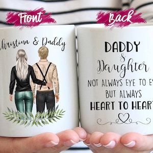 Peut inclure: Mug en c&eacute;ramique blanche avec un design personnalis&eacute;. Le devant pr&eacute;sente le texte "Christina & Daddy" au-dessus d'une illustration d'une fille et de son p&egrave;re. Le dos de la tasse indique "Daddy & Daughter" avec un motif de c&oelig;ur et le texte "Pas toujours face &agrave; face, mais toujours c&oelig;ur &agrave; c&oelig;ur."
