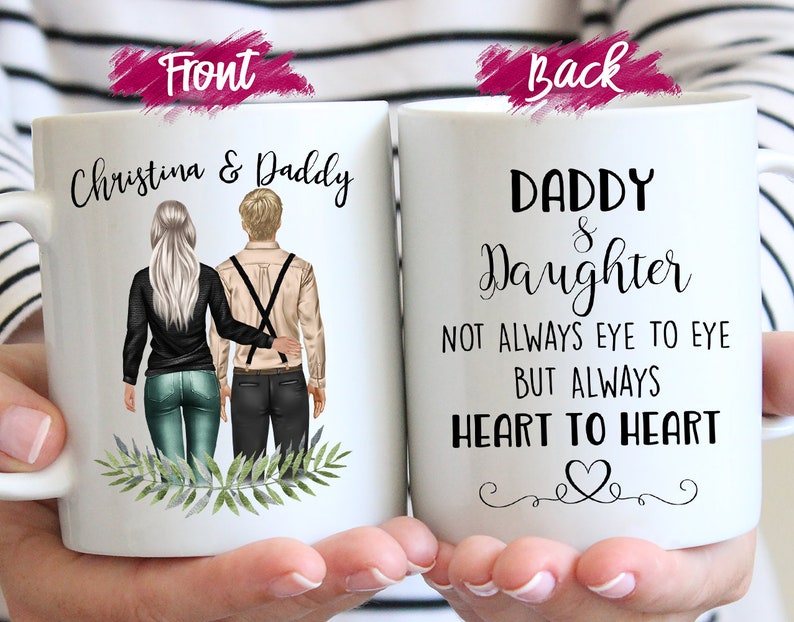 Peut inclure: Mug en c&eacute;ramique blanche avec un design personnalis&eacute;. Le devant pr&eacute;sente le texte "Christina & Daddy" au-dessus d'une illustration d'une fille et de son p&egrave;re. Le dos de la tasse indique "Daddy & Daughter" avec un motif de c&oelig;ur et le texte "Pas toujours face &agrave; face, mais toujours c&oelig;ur &agrave; c&oelig;ur."