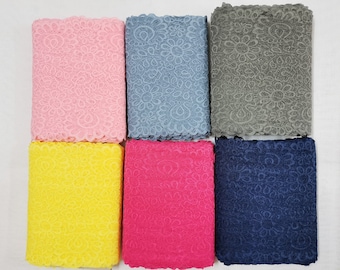 May include: Six fabric swatches with a floral lace pattern. The swatches are in pink, yellow, blue, grey, dark blue, and red.