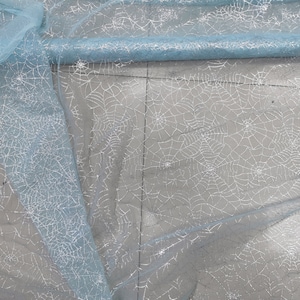 Peut inclure: Tulle de couleur bleu clair avec un motif d'araign&eacute;e en paillettes argent&eacute;es.