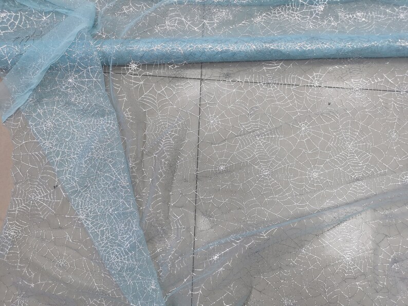 Peut inclure: Tulle de couleur bleu clair avec un motif d'araign&eacute;e en paillettes argent&eacute;es.