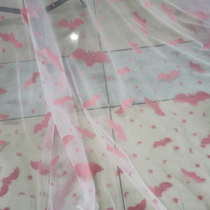 May include: White sheer fabric with a pink bat and star pattern.