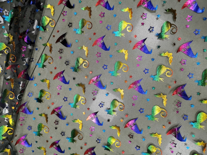 K&ouml;nnte beinhalten: Regenbogenfarbener, schimmernder Hexenhut und Sterne auf schwarzem Netzstoff. Dieser Stoff ist perfekt zum Basteln von Halloween-Kost&uuml;men, Dekorationen und Accessoires.