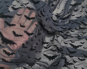 Peut inclure: Tissu en maille noire transparente avec un motif répété de chauves-souris en velours noir.