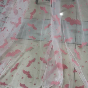 May include: White sheer fabric with a pink bat and star pattern.