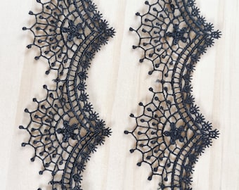 Peut inclure: Garniture en dentelle noire avec un motif floral délicat. La garniture a un bord festonné et est parfaite pour ajouter une touche d'élégance à tout projet.