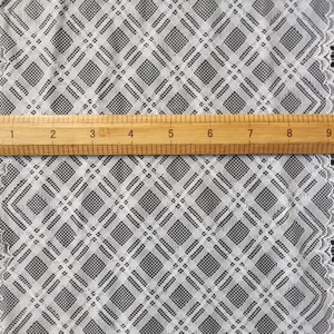 May include: White lace trim with a diamond pattern. The lace is approximately 10 inches wide.