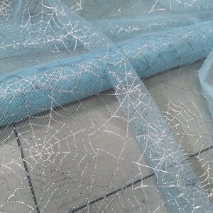 Peut inclure: Tulle de couleur bleu clair avec un motif d'araign&eacute;e en paillettes argent&eacute;es.