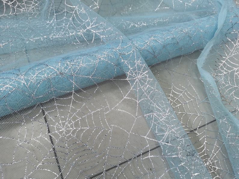 Peut inclure: Tulle de couleur bleu clair avec un motif d'araign&eacute;e en paillettes argent&eacute;es.