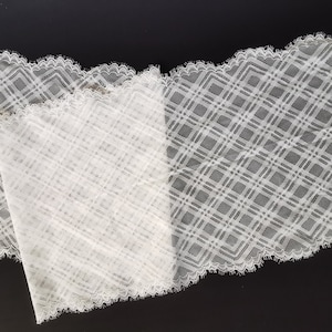 May include: White lace trim with a diamond pattern. The lace has a scalloped edge.