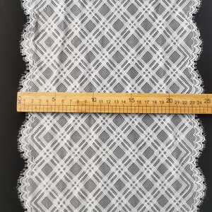 May include: White lace trim with a diamond pattern. The trim is approximately 29 inches long and has a scalloped edge.