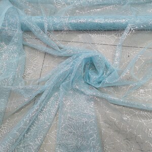 Peut inclure: Tissu de tulle bleu clair avec un motif d'araign&eacute;e en paillettes argent&eacute;es.