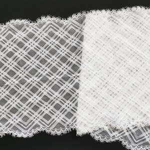 May include: White lace trim with a geometric diamond pattern. The lace has a scalloped edge.