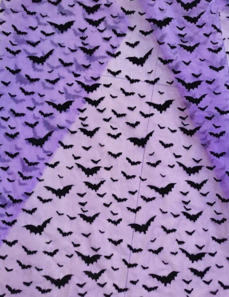 May include: Purple sheer fabric with a black bat pattern. The bats are scattered randomly across the fabric.