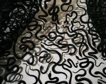 Peut inclure: Motif de serpents noirs sur fond blanc. Les serpents sont représentés dans diverses poses, certains enroulés, d'autres étirés. L'image est à fort contraste, les serpents noirs se détachant nettement sur la surface blanche.