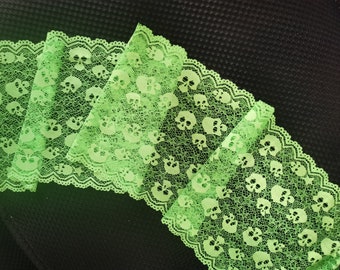 Peut inclure: Garniture de dentelle verte avec des crânes et un bord festonné. La dentelle est délicate et présente un motif répété de crânes.