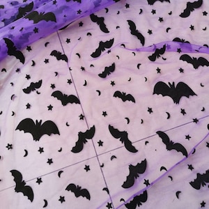 May include: Purple sheer fabric with a black bat and star pattern.