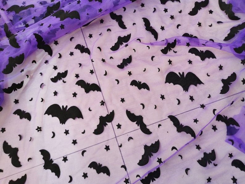 May include: Purple sheer fabric with a black bat and star pattern.