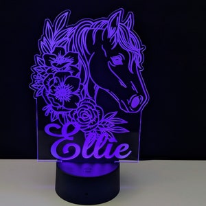 May include: A purple LED night light with a horse head silhouette and floral design. The name "Ellie" is written below the horse's head.