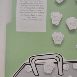 May include: A green and white paper craft with a quote from the Book of Mormon about the sacrament. The quote reads, "O God, the Eternal Father, we ask thee in the name of thy Son, Jesus Christ, to bless and sanctify this [water] to the souls of all those who drink of it, that they may do it in remembrance of the blood of thy Son, which was shed for them, that they may witness unto thee, O God, the Eternal Father, that they do always remember him, that they may have his Spirit to be with them. Amen" (D&C 20.79 and Moroni 5).