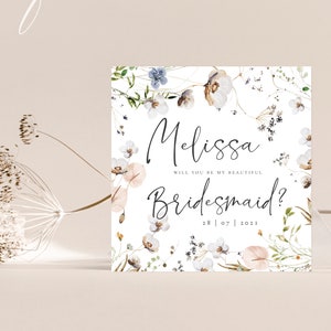 May include: A white card with a floral design and the text "Melissa, Will you be my beautiful Bridesmaid? 28 | 07 | 2021"