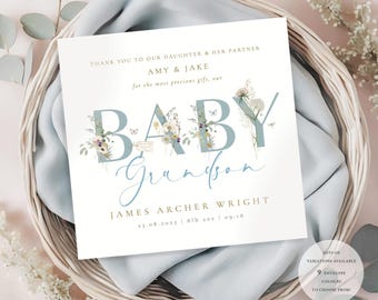 Può includere: Un biglietto bianco con lettere floreali blu che recitano "Baby Grandson" con il nome "James Archer Wright" e la data "13.08.2025 | 8lb 20x | 09:18". Il biglietto ha un design floreale con farfalle e uno sfondo blu chiaro.