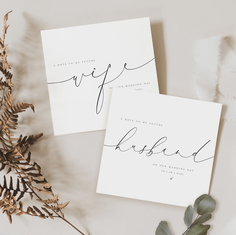 May include: Two white cards with black calligraphy. The top card says "A note to my future wife on our wedding day '22". The bottom card says "A note to my future husband on our wedding day 18 | 08 | 2022".