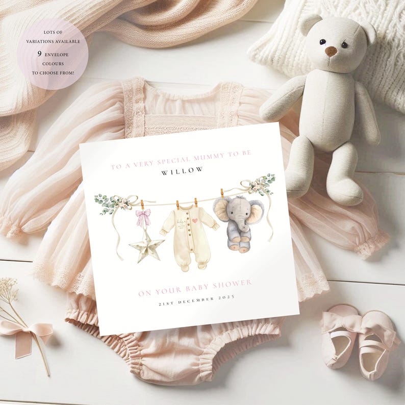 May include: A baby shower greeting card with a watercolor illustration of baby clothes and an elephant hanging on a clothesline. The card reads "To a very special mummy to be Willow" and "On your baby shower 21st December 2025". The card is surrounded by baby clothes and a teddy bear.