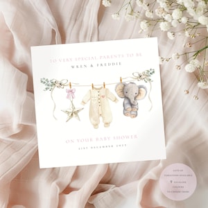 May include: A baby shower card with the text "TO VERY SPECIAL PARENTS TO BE WREN & FREDDIE ON YOUR BABY SHOWER 21ST DECEMBER 2025". The card features illustrations of baby clothes, a star, and an elephant. The card is on a pink background.