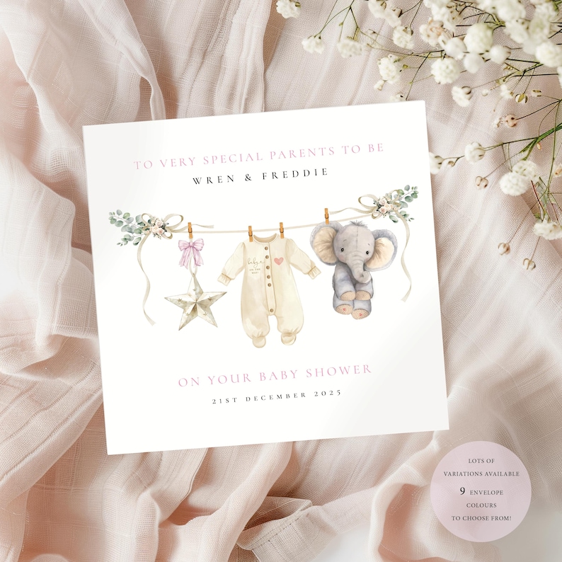 May include: A baby shower card with the text "TO VERY SPECIAL PARENTS TO BE WREN & FREDDIE ON YOUR BABY SHOWER 21ST DECEMBER 2025". The card features illustrations of baby clothes, a star, and an elephant. The card is on a pink background.