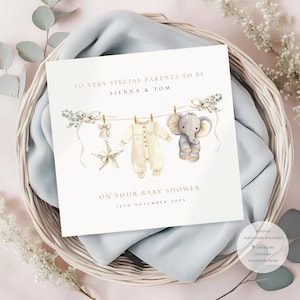 May include: A baby shower invitation card with the text "TO VERY SPECIAL PARENTS TO BE SIENNA & TOM ON YOUR BABY SHOWER 17TH NOVEMBER 2025". The card features watercolor illustrations of a star, baby clothes, and an elephant.