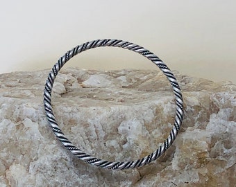 Pulsera de brazalete retorcido de plata de ley.