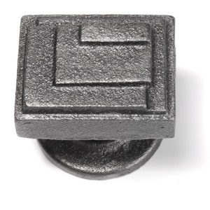May include: A square, grey cast iron door knob with a geometric design. The knob has a round base.