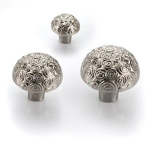 May include: Three silver cabinet knobs with a swirl pattern. The knobs are different sizes.
