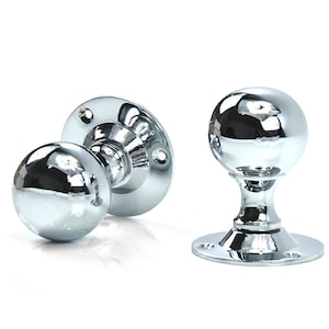 May include: Two polished chrome door knobs with round handles and a circular base.