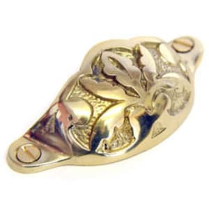 May include: Brass cabinet pull with a decorative floral design. The pull has a curved shape and two screw holes.