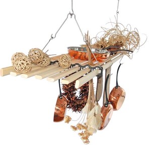 May include: A decorative hanging kitchen rack made of wood and metal, featuring copper pots and pans. The rack is adorned with decorative woven spheres and dried plants, creating a rustic aesthetic. The rack is suspended from a metal hook.