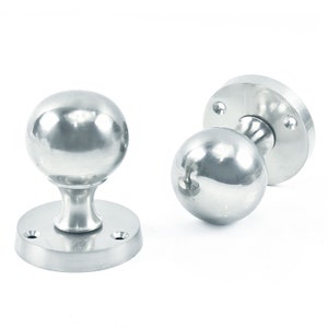 May include: Two silver door knobs with round handles and a circular base.