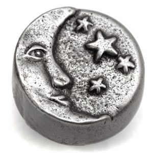 May include: A silver-toned metal charm in the shape of a crescent moon with a face and five stars.