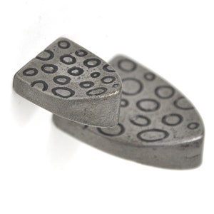 May include: Two silver-toned metal cufflinks with a circular pattern. The cufflinks are shaped like a shield.