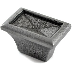 May include: A grey metal cabinet knob with a rectangular shape and a textured surface.