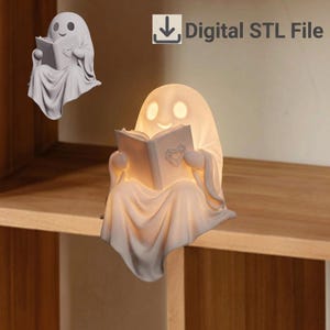 May include: A white ghost-shaped lamp reading a book with a heart detail on the cover. The ghost has hollow eyes and a smiling mouth. The text Digital STL File is displayed in the upper right corner with a download icon.