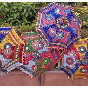 May include: Five colourful, patterned umbrellas with fringe trim and mirror embellishments. The umbrellas are made of fabric and have a traditional Indian design.