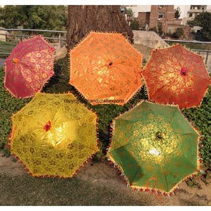 May include: Five decorative umbrellas with intricate patterns and gold accents. The umbrellas are in various colours, including red, orange, yellow, and green.