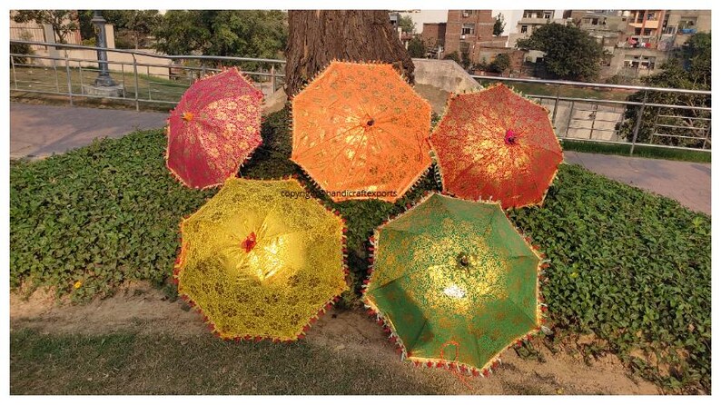 May include: Five decorative umbrellas with intricate patterns and gold accents. The umbrellas are in various colours, including red, orange, yellow, and green.