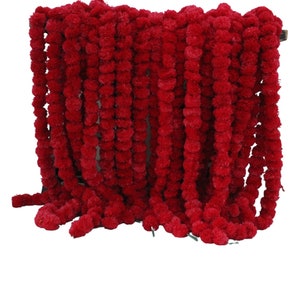 Könnte beinhalten: Eine lange Girlande aus roten Ringelblumen-Blütenpompons. Die Girlande besteht aus vielen einzelnen Pompons, die aneinandergereiht sind.