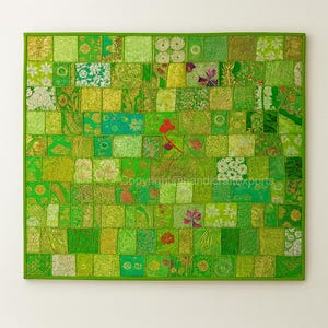 May include: A patchwork textile in shades of green, with diverse patterns and textures. The square design has a green border. A red flower is in the center. The text "copyright@nandicraftexports" is visible.