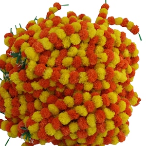 May include: A garland of artificial marigold flowers, with alternating orange and yellow blooms. The garland is made of many individual flower clusters, creating a full and lush look.