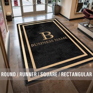 May include: A black welcome mat with a gold border and the letter "B" and the text "BUSINESS NAME" in gold.